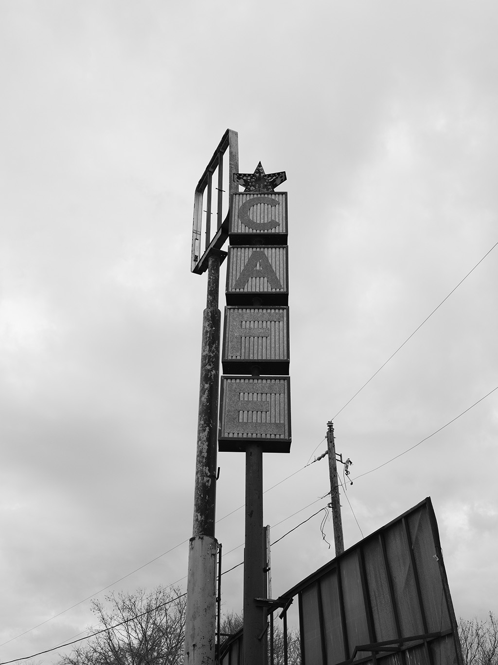 Black and White photography of a sign from an abandoned gas station