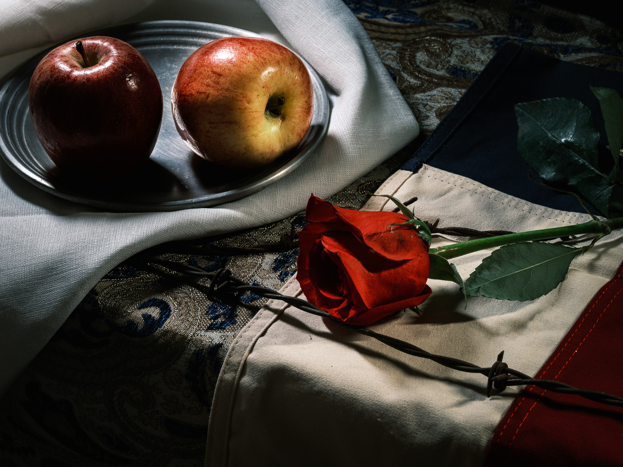 Still-life photography of apples, texas flag, and a red rose